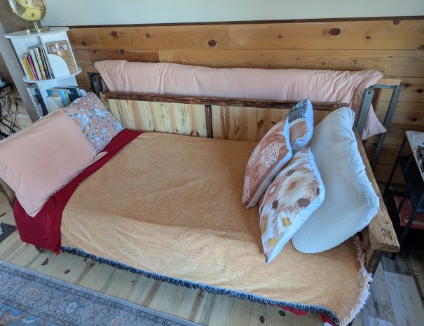 LIVING ROOM: A look at the blue pine construction of the daybed, which is a standard twin, 38x75", which is also made up for day use. Enjoy the 20-mile view to Snowhaven, Cottonwood Butte and Nez Perce.